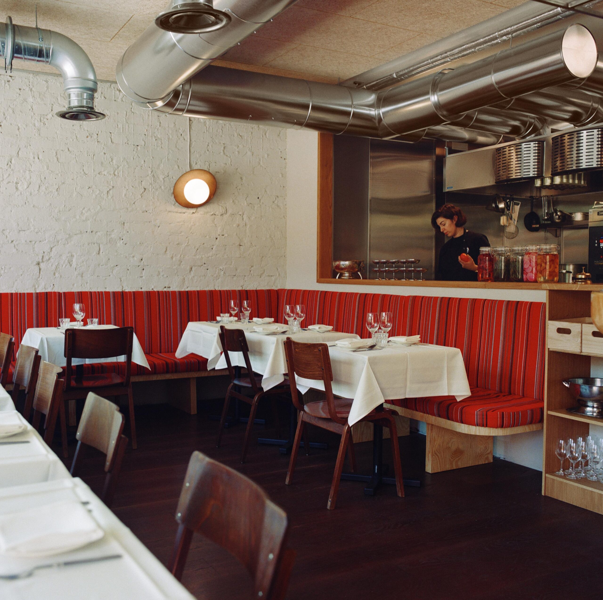 Maukku's interior. Tables, and a person behind the counter.