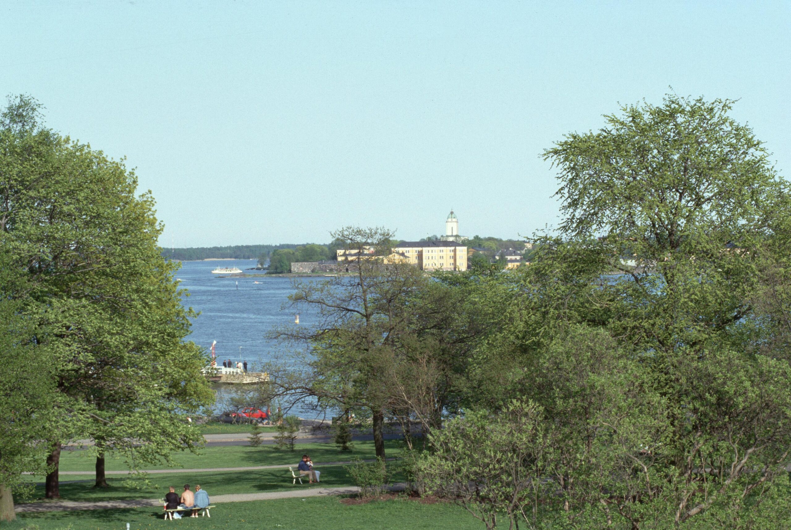 View from Kaivopuisto park. People in the park and the sea in the background.