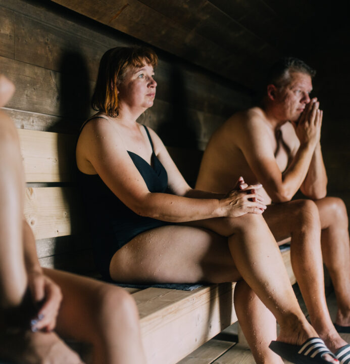 A group of people sitting in a sauna in Lonna, Helsinki