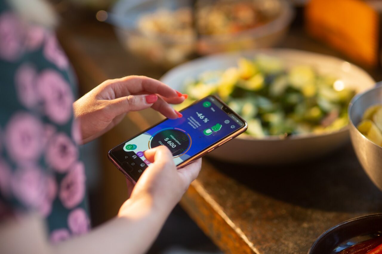 a person holding a phone on a foodtech app