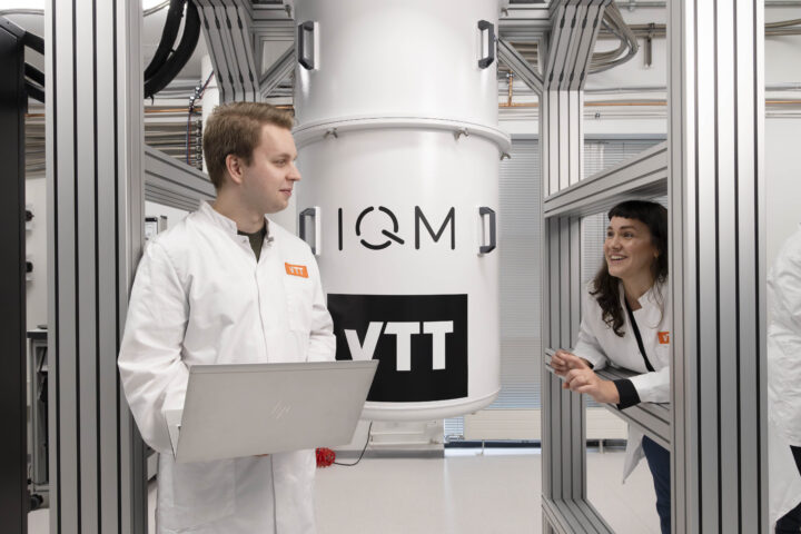 Two researchers in front of a Quantum computer by VTT and IQM to develop Quantum tech in Helsinki