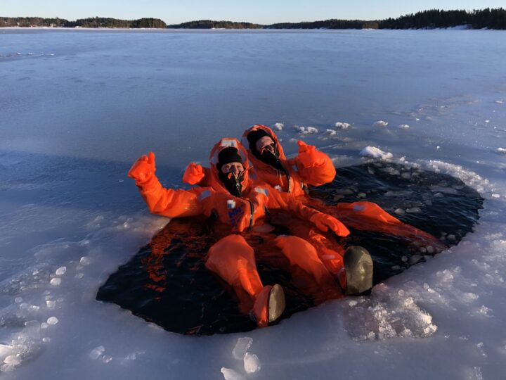 Two people in orange survival jumpsuits in ice