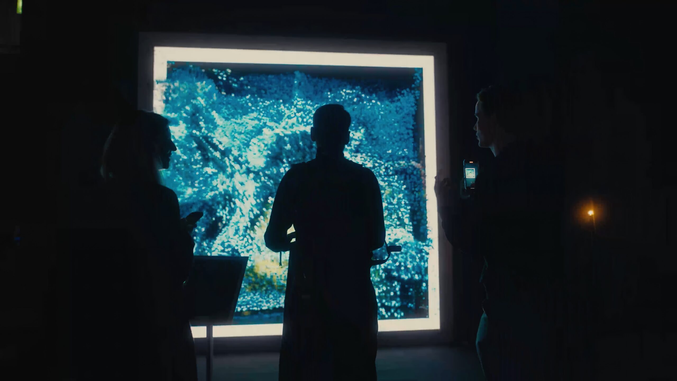 a group of people standing in front of a large screen