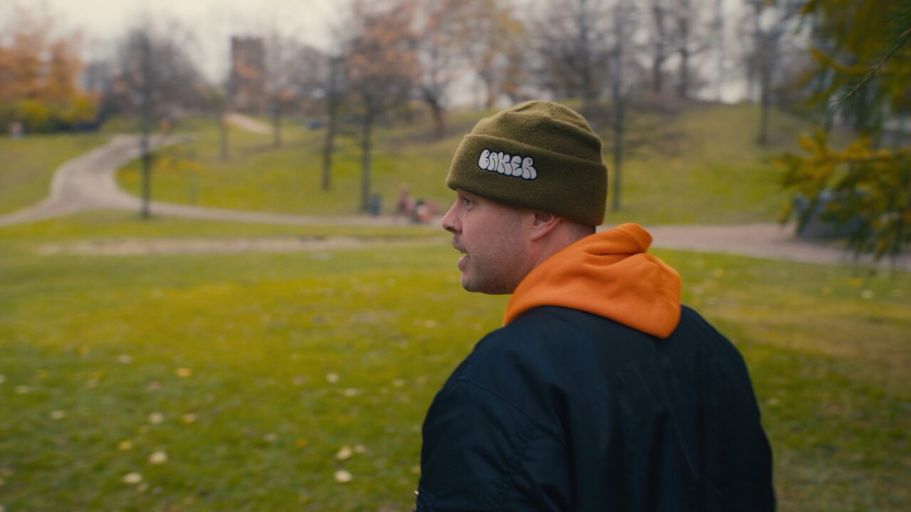 a man in a beanie looking away from the camera