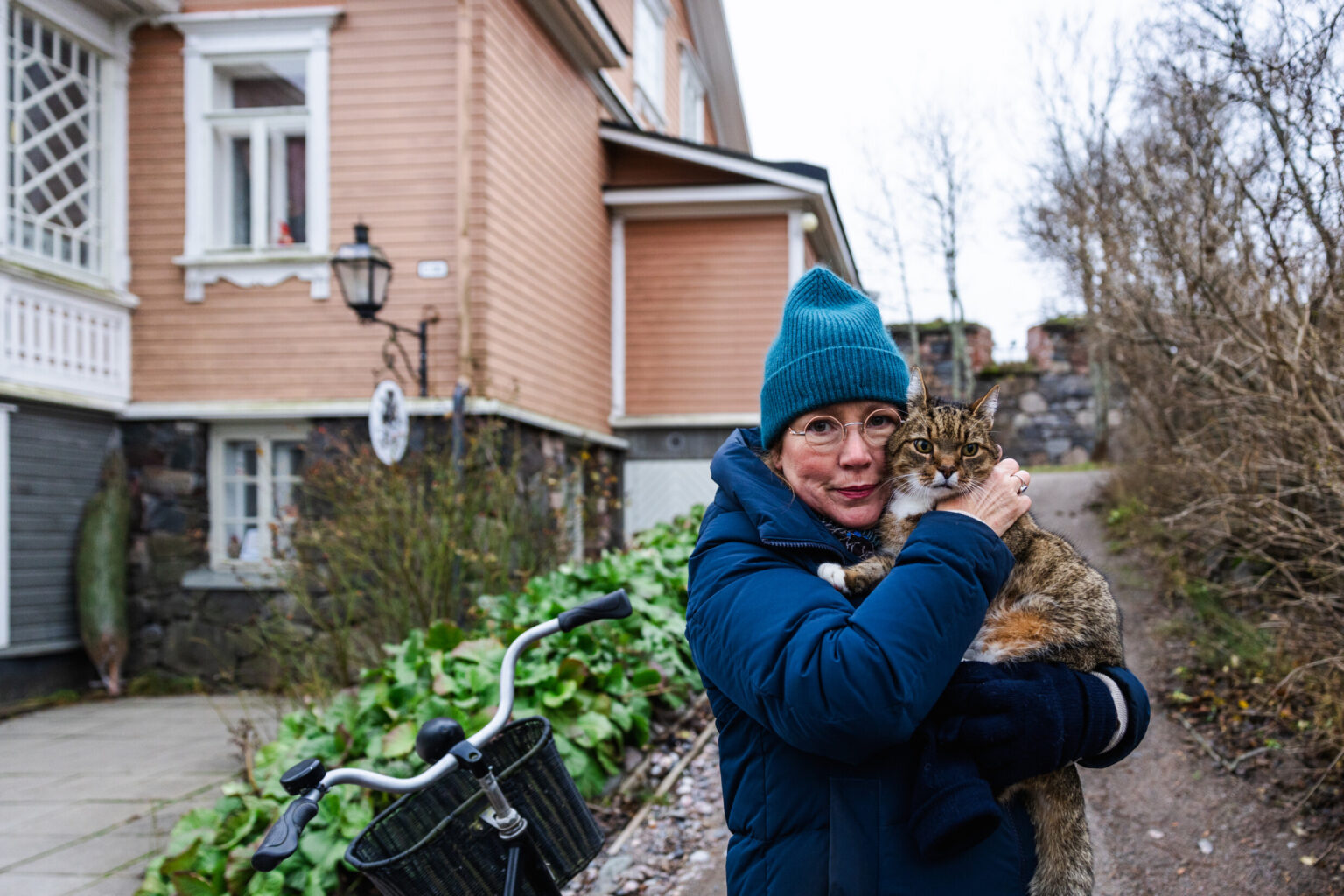 Finnish woman holding pet cat on the island Suomenlinna in Helsinki