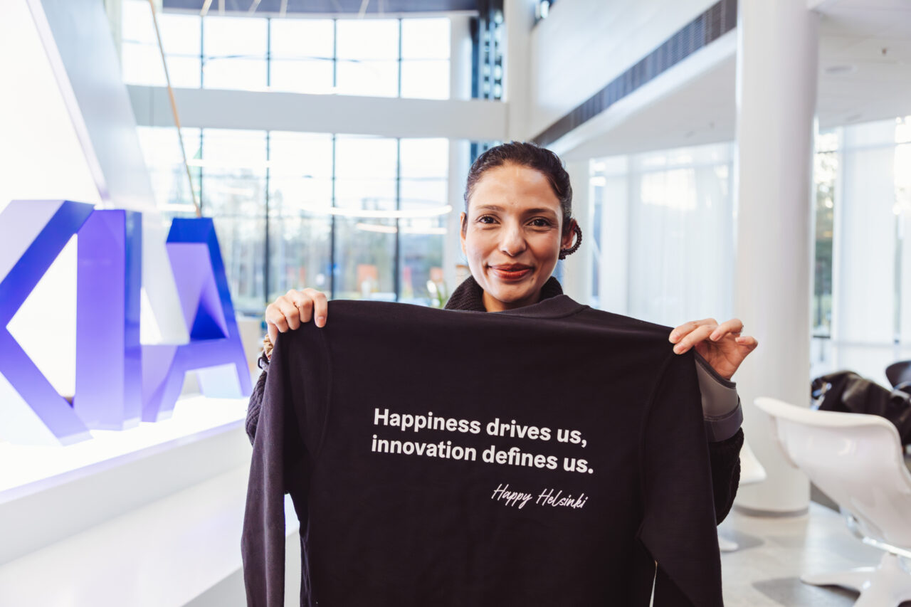 a woman holding a black shirt with white text