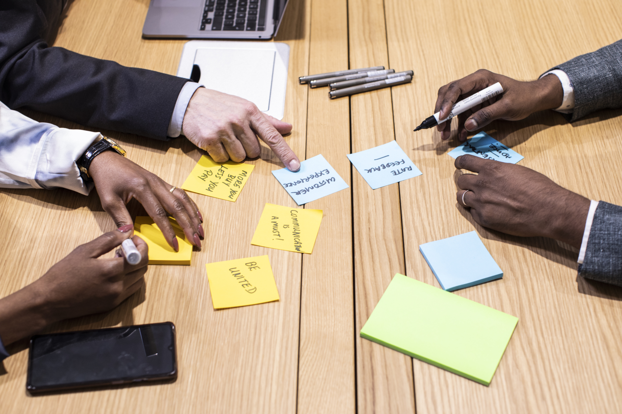 a group of people sitting around a table with sticky notes