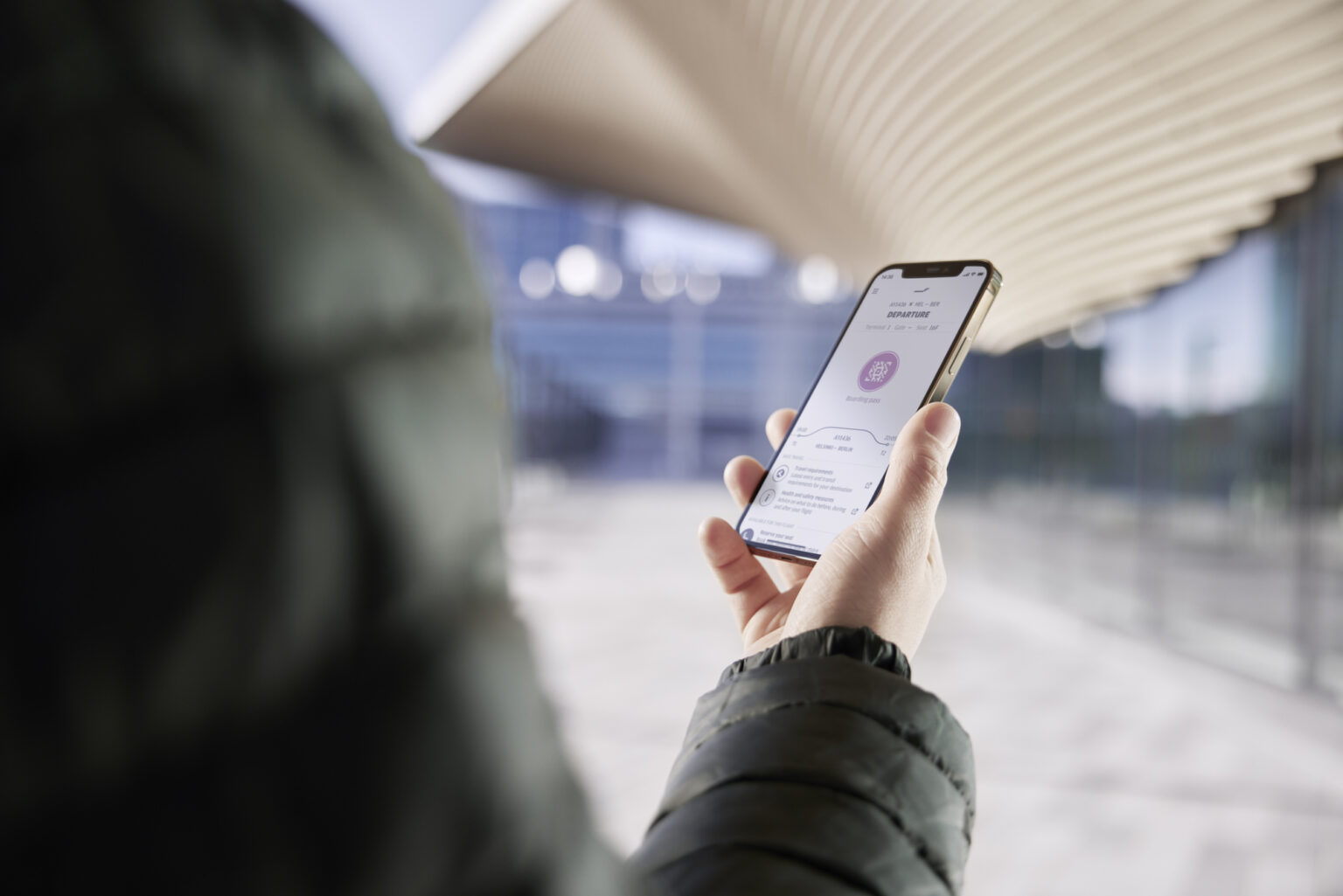 a person holding a phone at the Helsinki airport