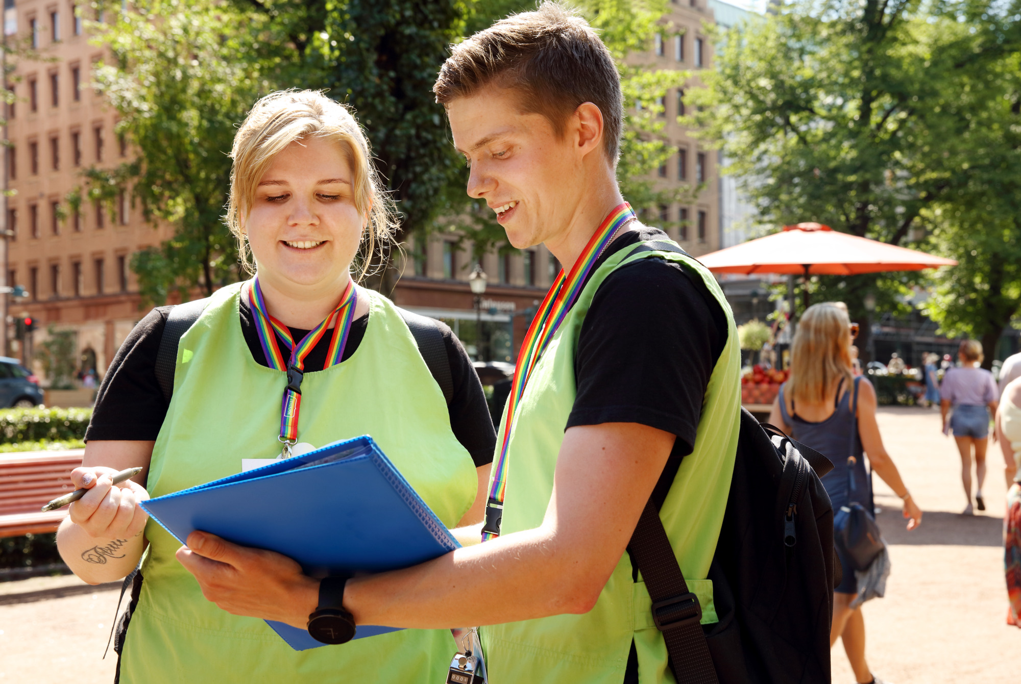 two Helsinki Helpers wearing matching green vests