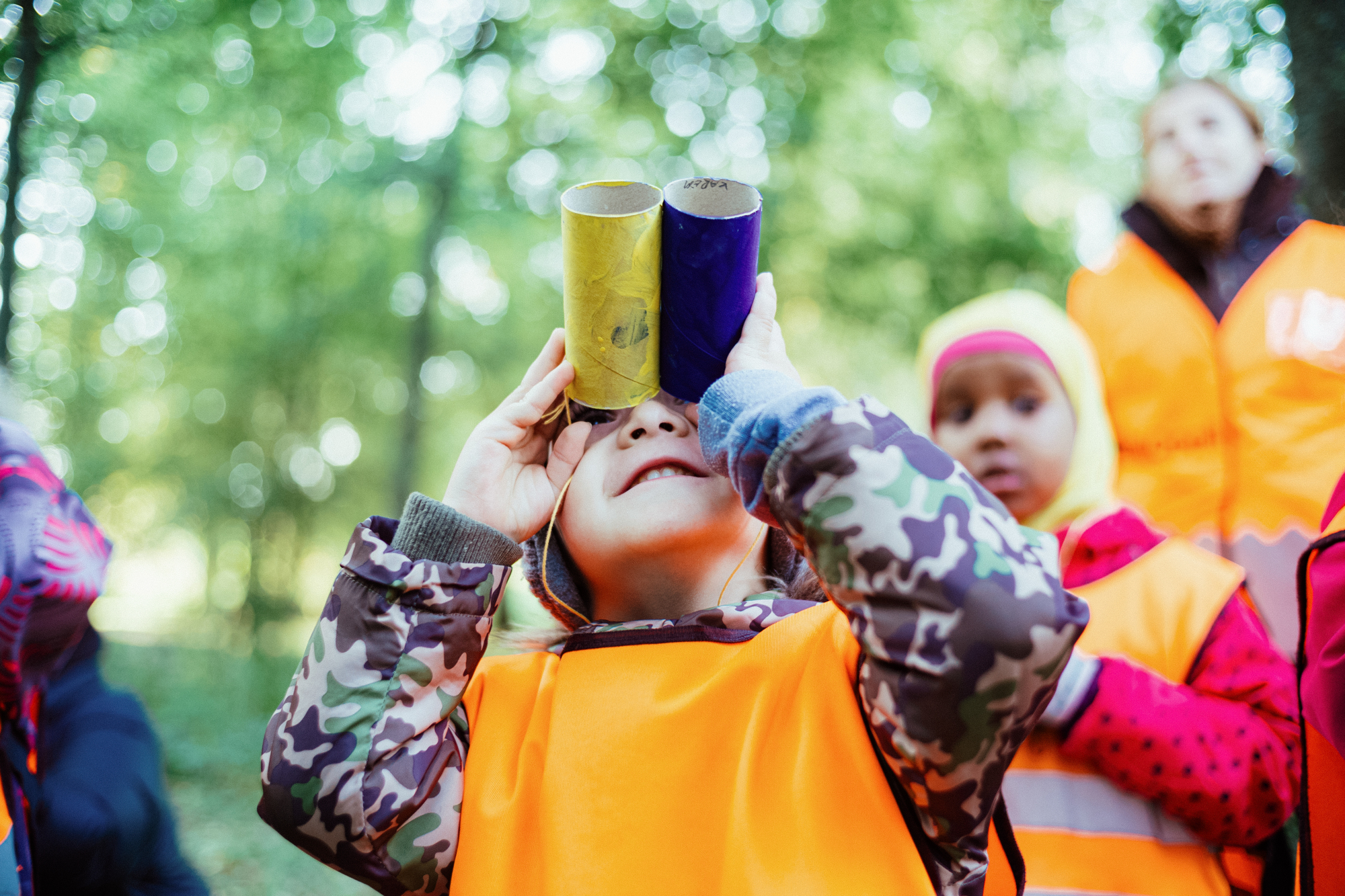 a child looking through two paper tubes