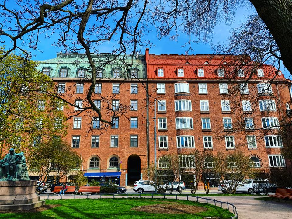 a building with trees and cars parked in front of it