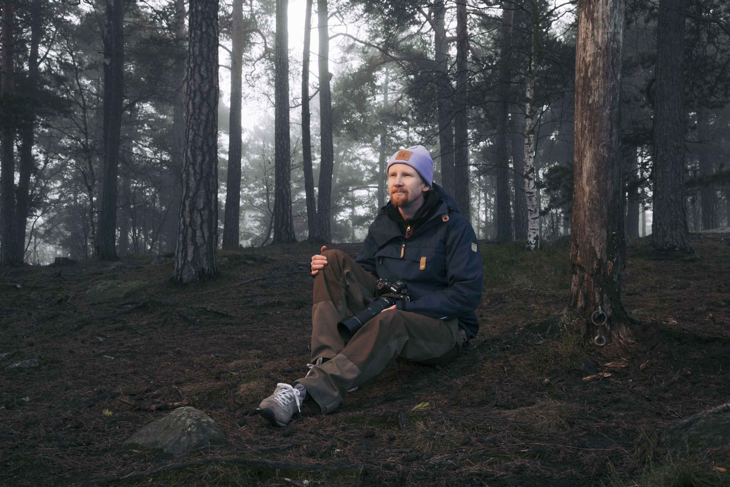 Wildlife photographer Konsta Punkka in a Helsinki forest with his camera.